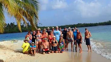 A group of people standing on top of a sandy beach

Description automatically generated