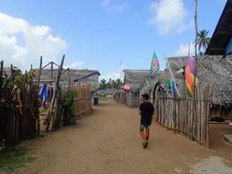 A group of people walking down a dirt road

Description automatically generated