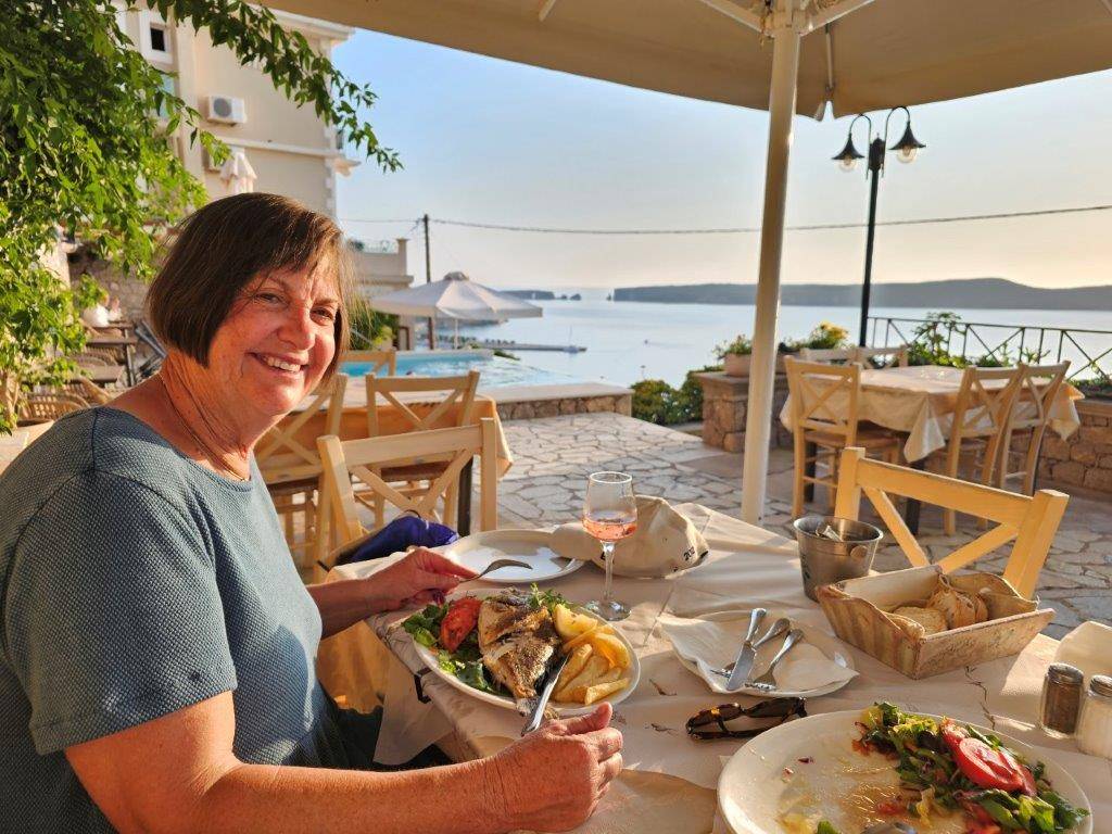 A person sitting at a table with food

Description automatically generated