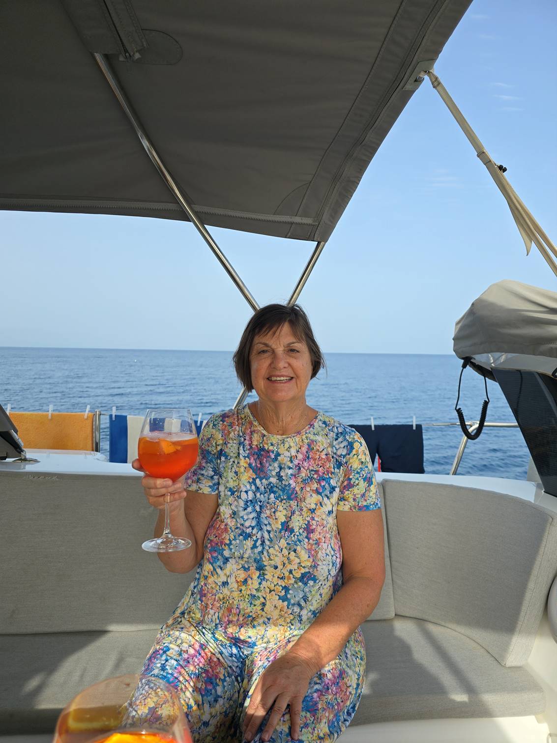 A person sitting on a boat holding a drink

Description automatically generated