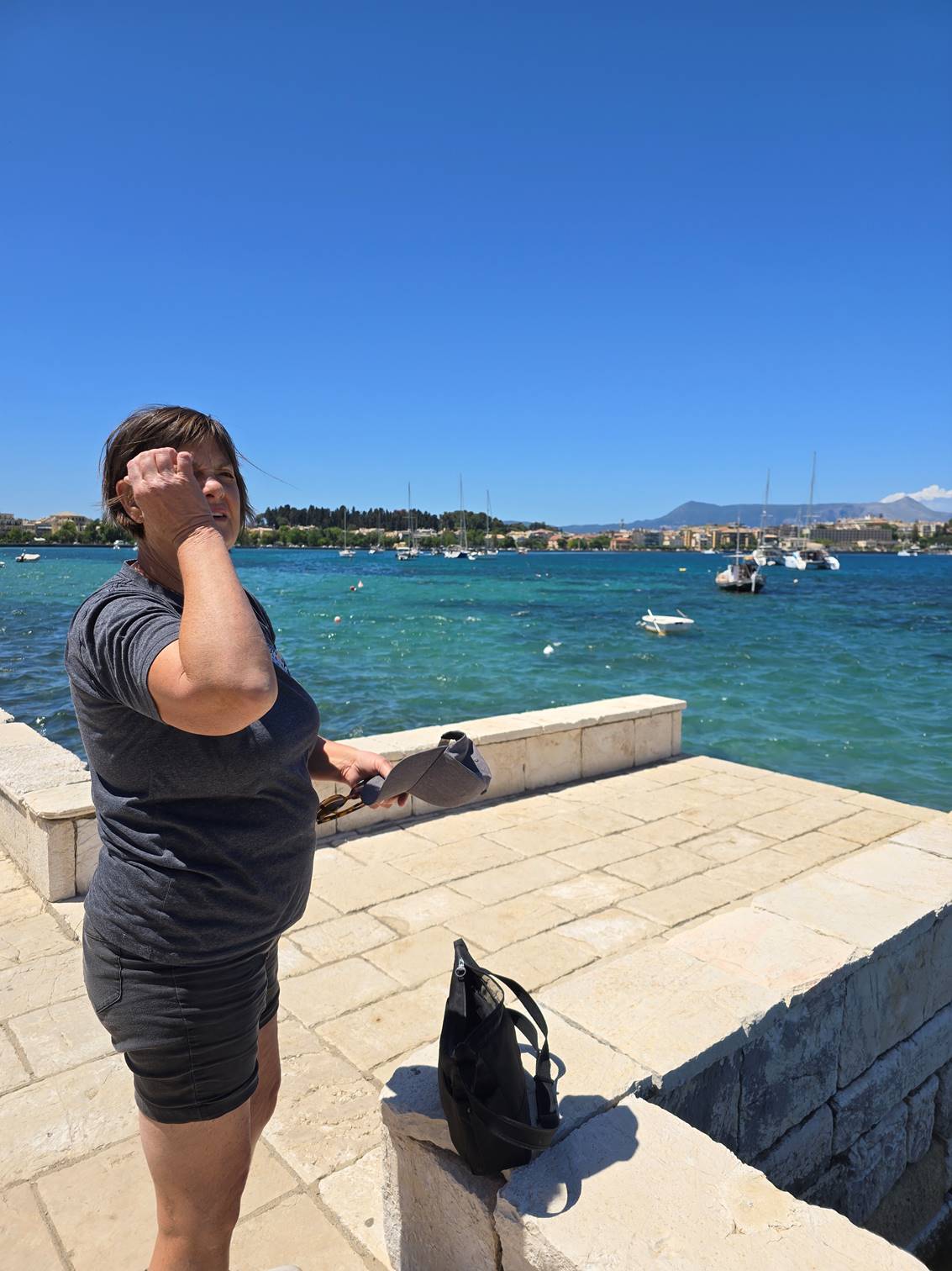 A person standing on a stone ledge near water

Description automatically generated