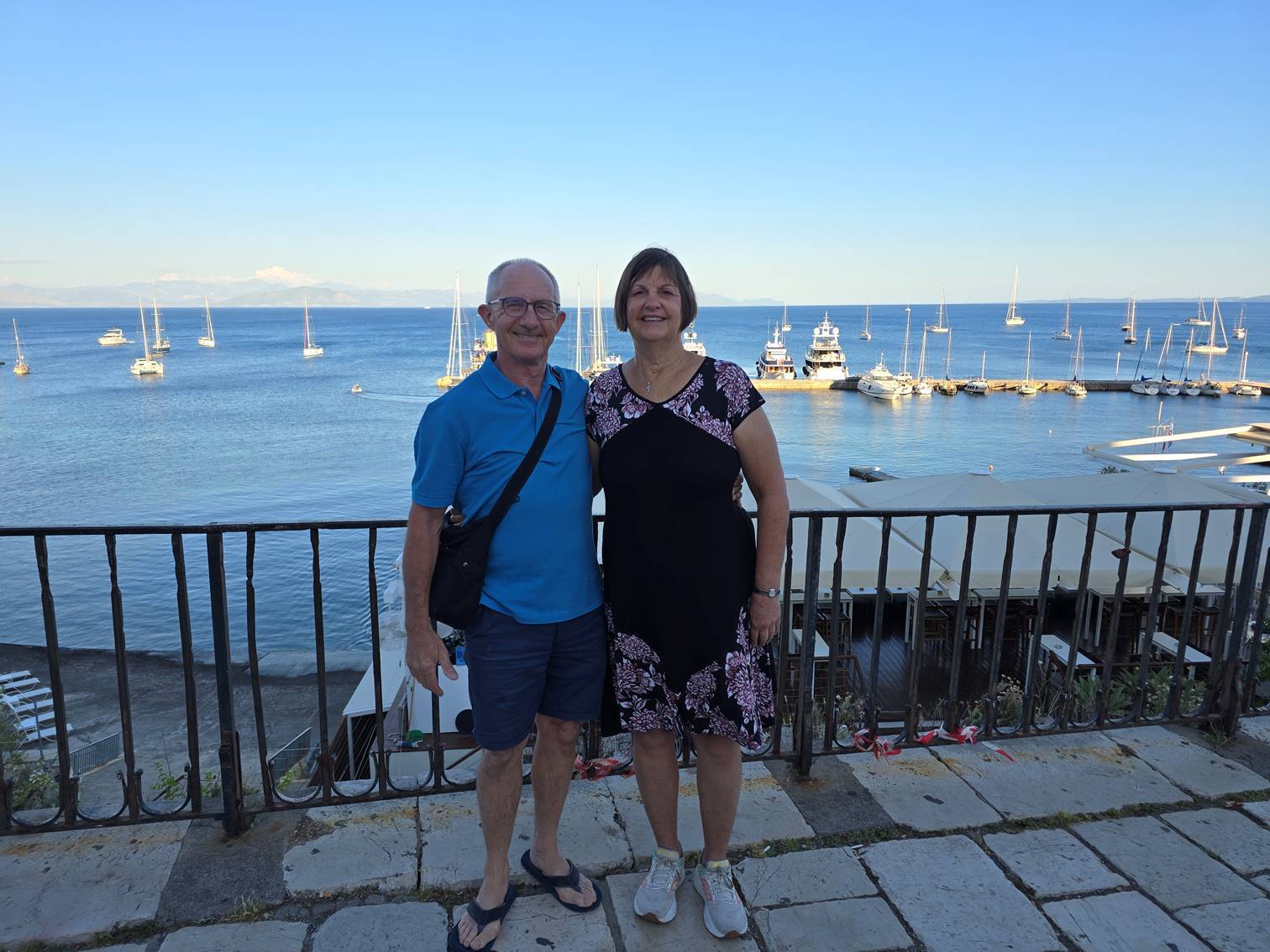 A person and person sitting on a railing

Description automatically generated