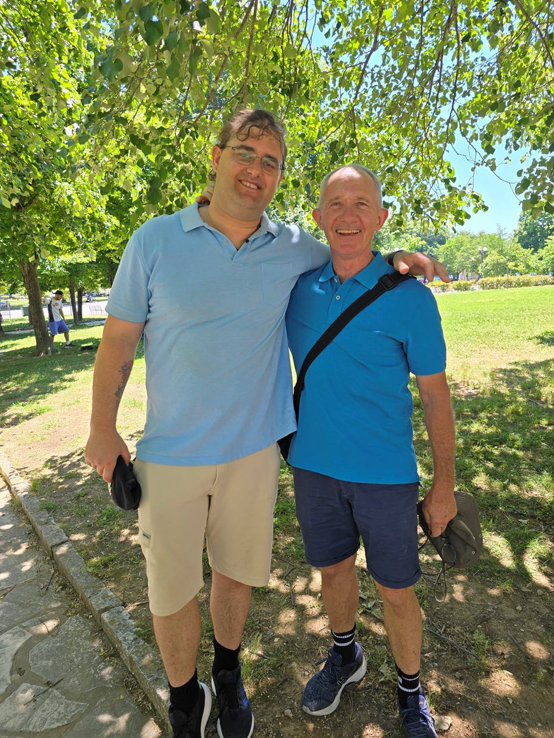 Two men standing in a park

Description automatically generated