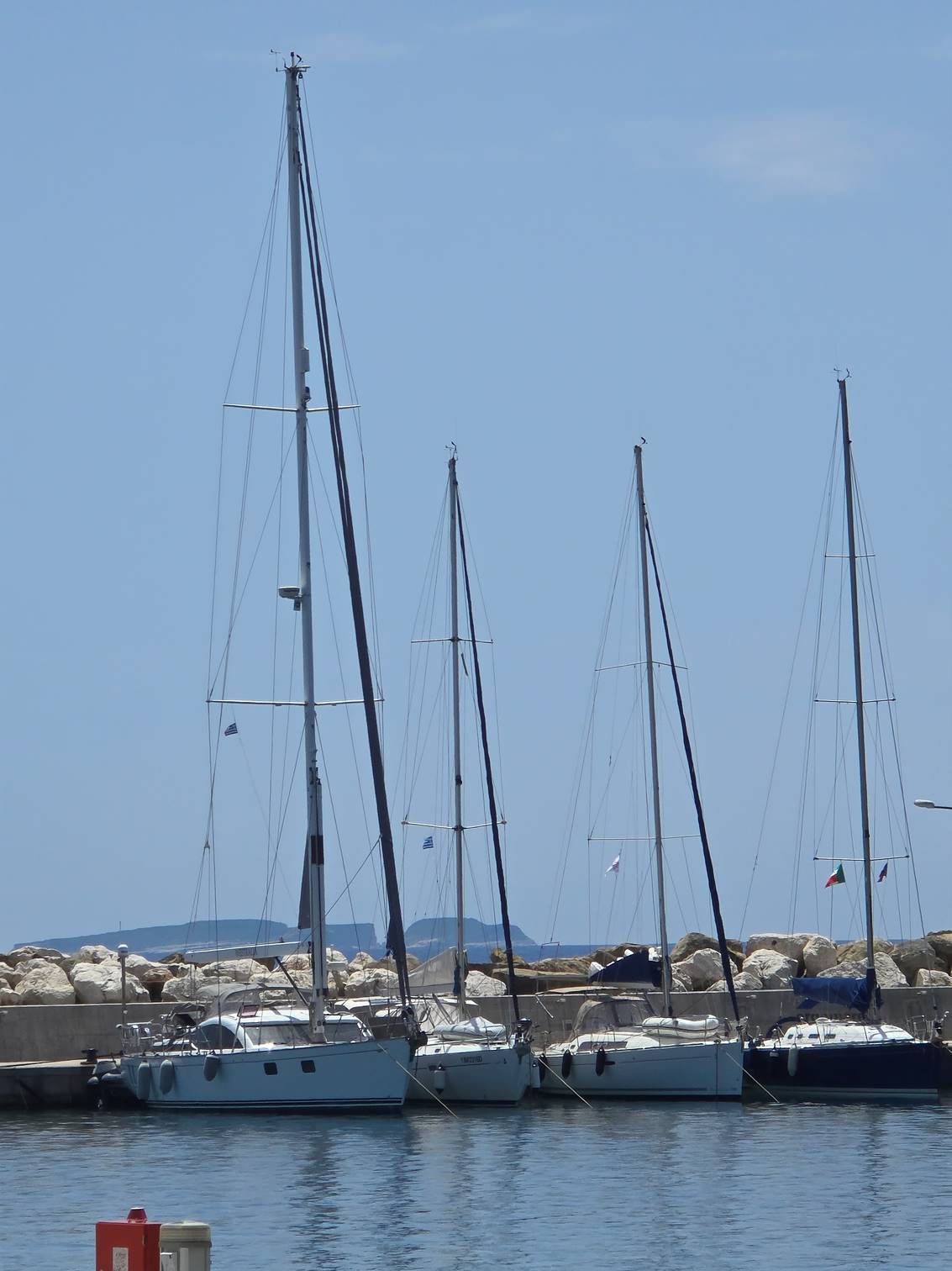 A group of sailboats on a dock

Description automatically generated