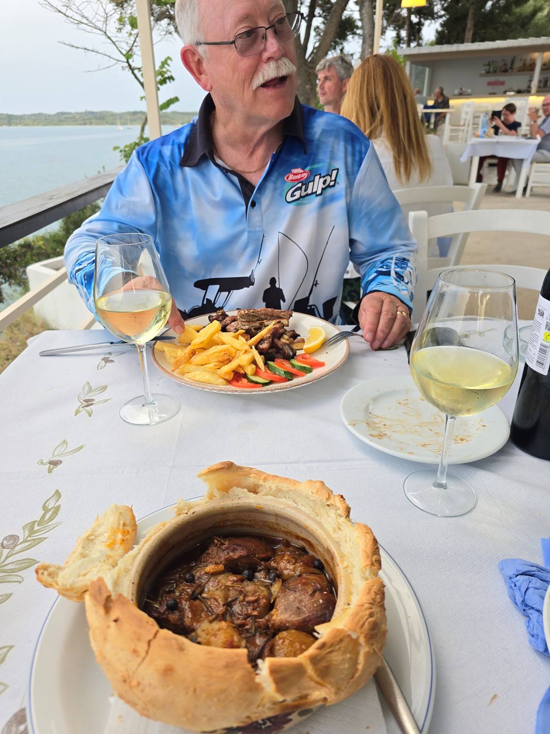 A person sitting at a table with food

Description automatically generated