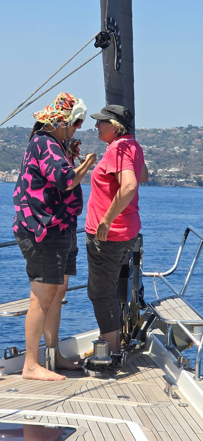 A person and person standing on a boat

Description automatically generated