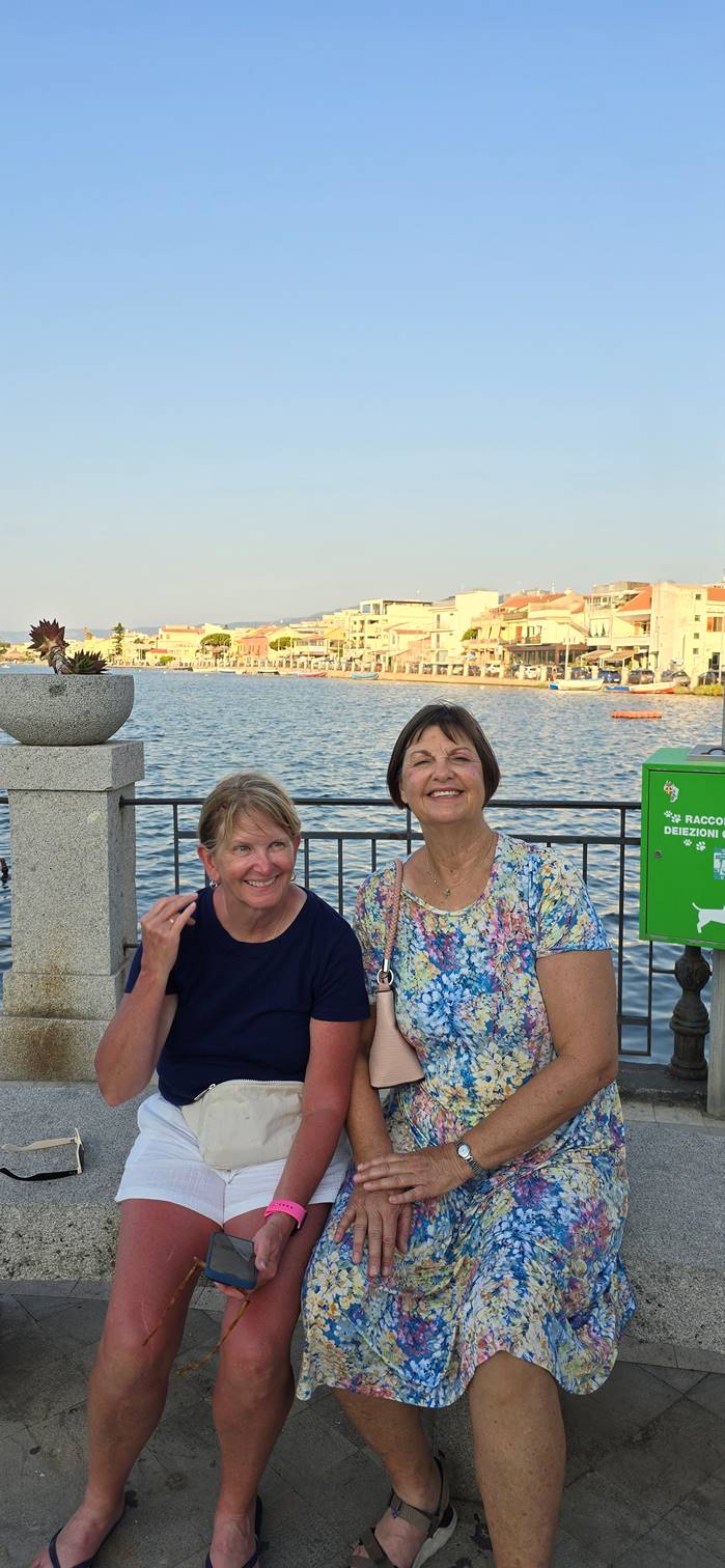 A person and person sitting on a bench

Description automatically generated